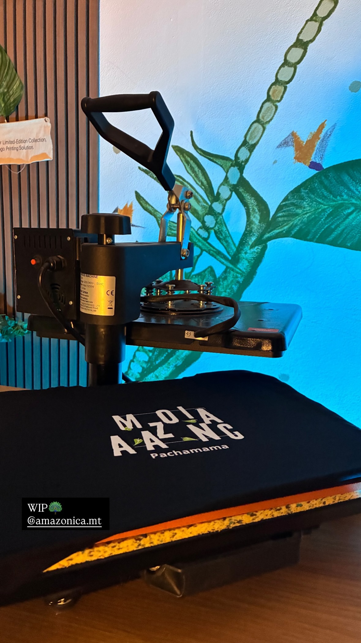 Heat press printing on a black garment inside the Amazonica studio